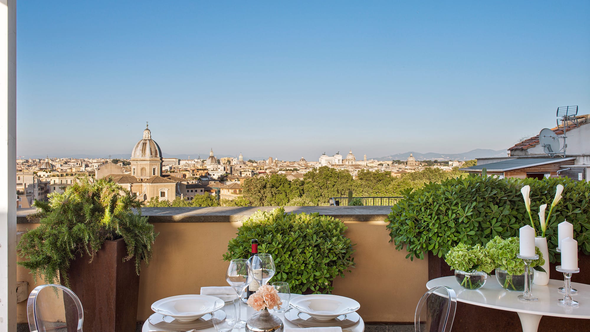 a table set up on a balcony with a city in the background