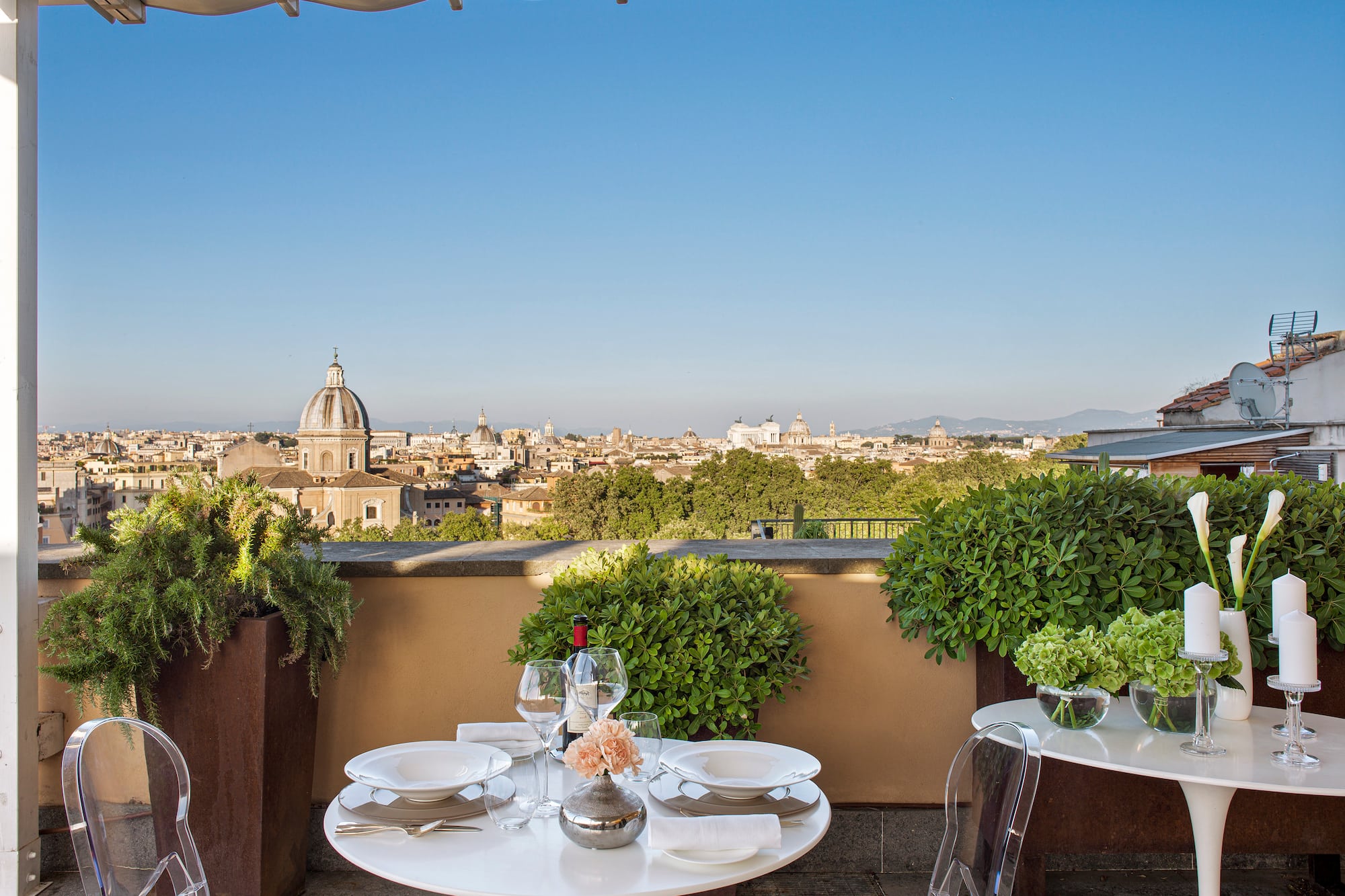 a table set up on a balcony with a city in the background