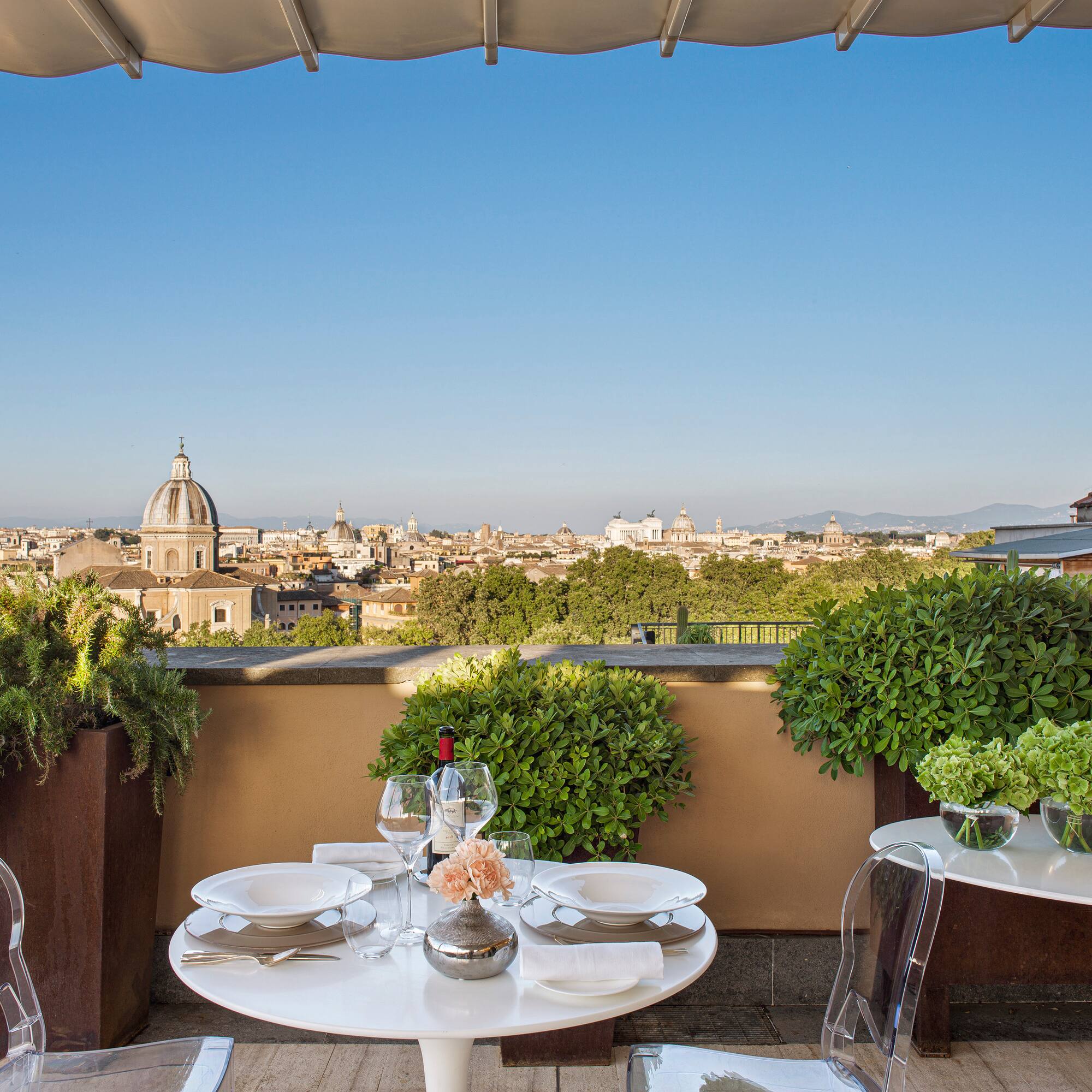 a table set up on a balcony with a city in the background
