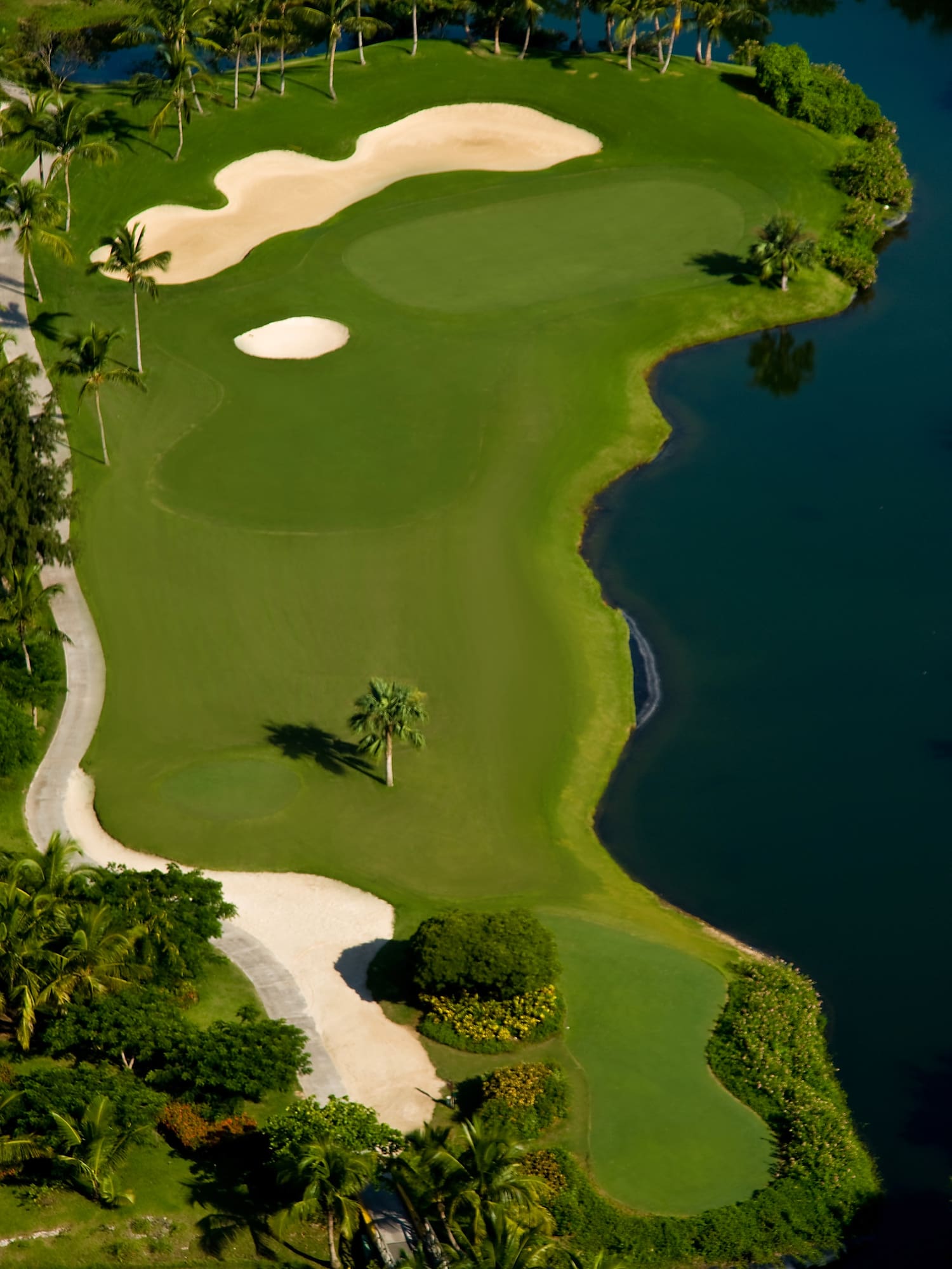 a golf course with sand bunkers and water