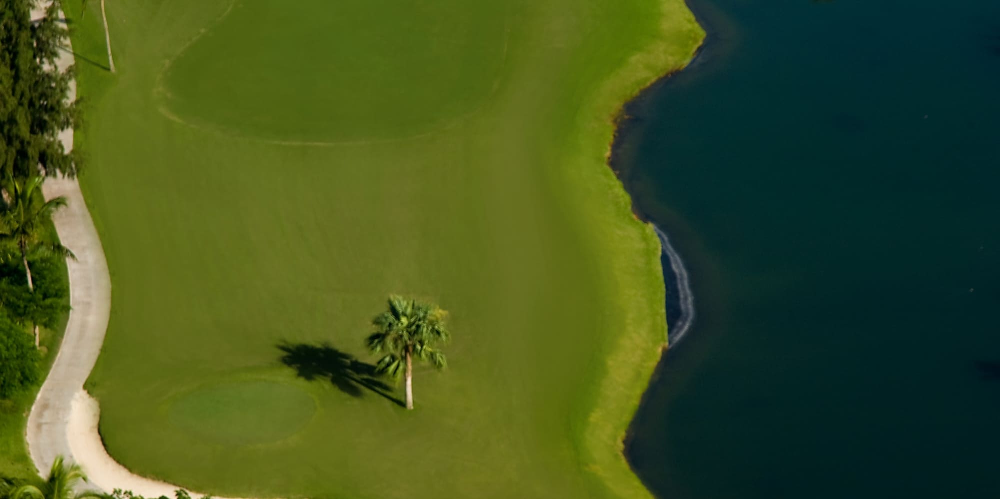 a golf course with sand bunkers and water