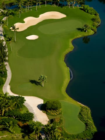a golf course with sand bunkers and water