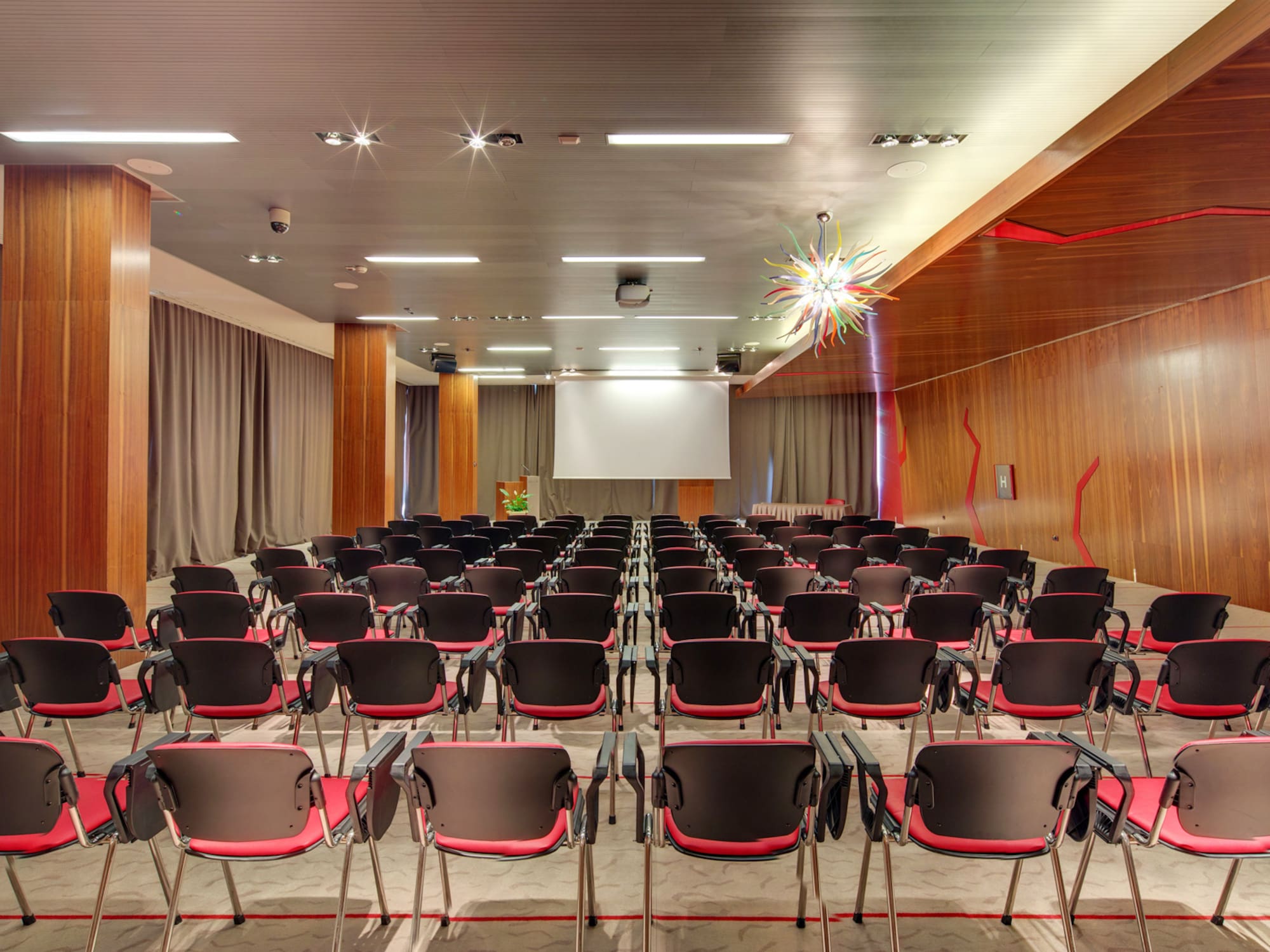 a room with many chairs and a projector screen