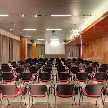 a room with many chairs and a projector screen