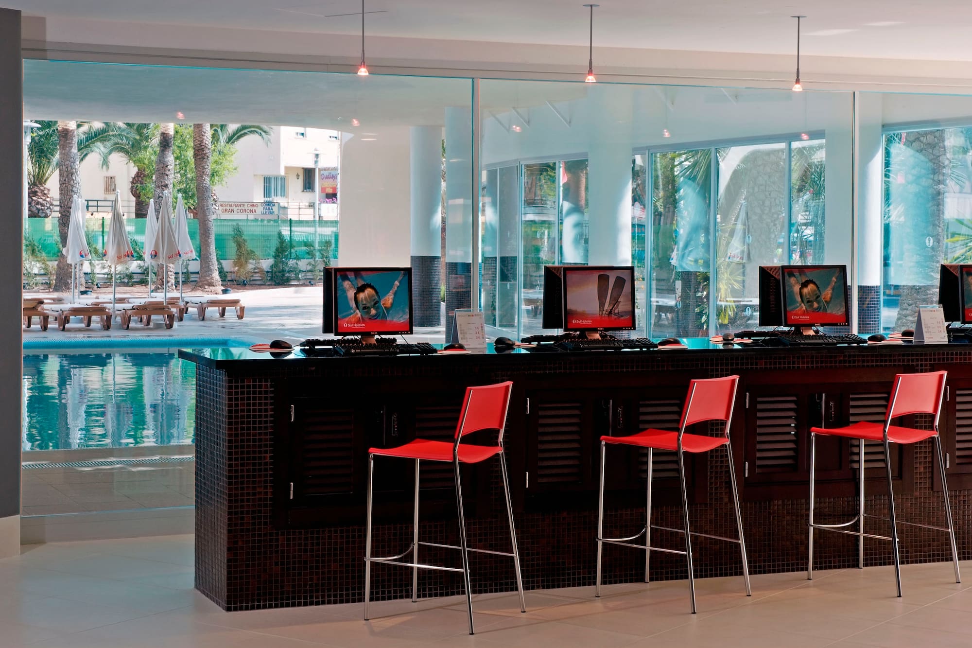 a room with a bar with computers and chairs