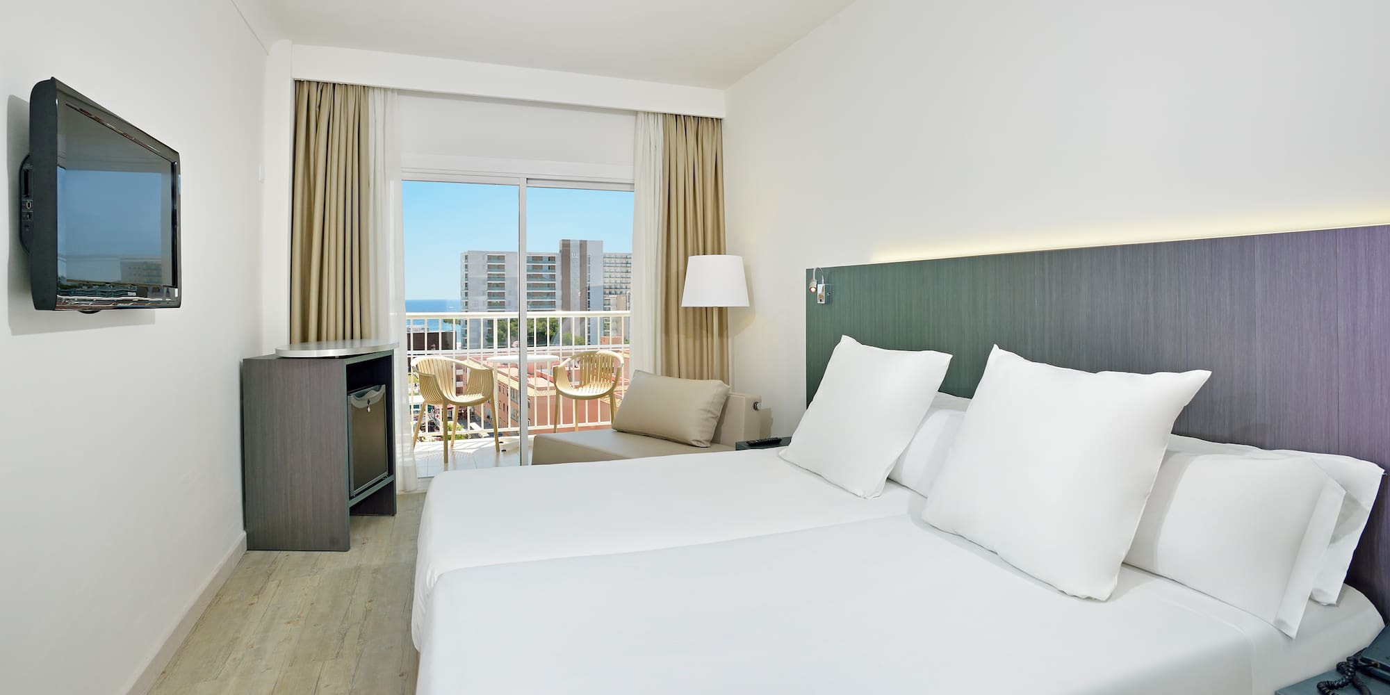 a hotel room with white bedding and a balcony
