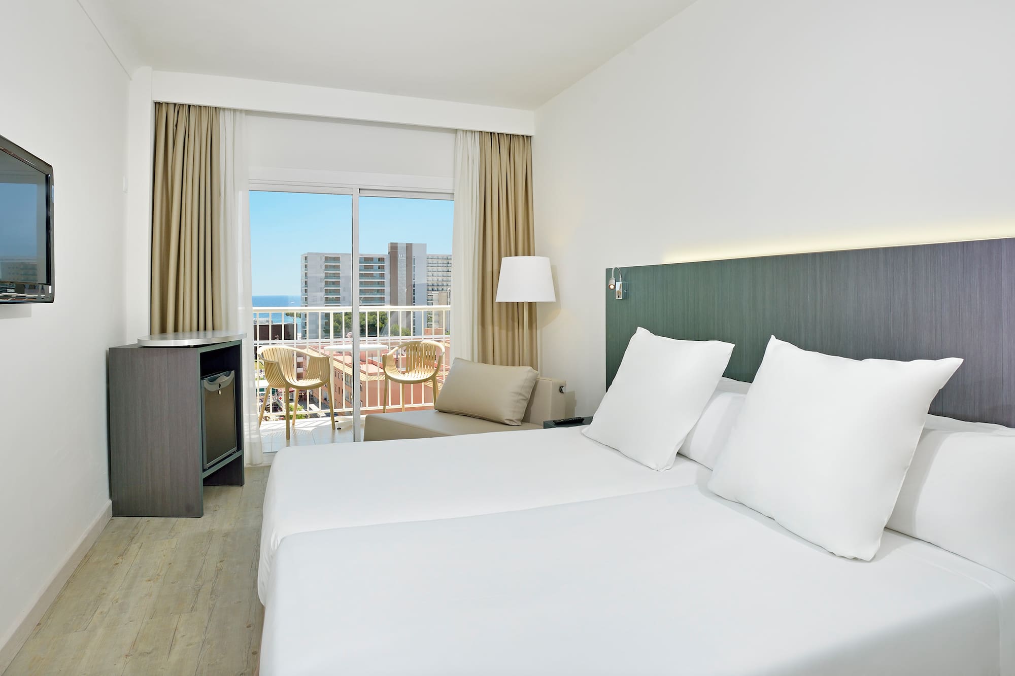 a hotel room with white bedding and a balcony