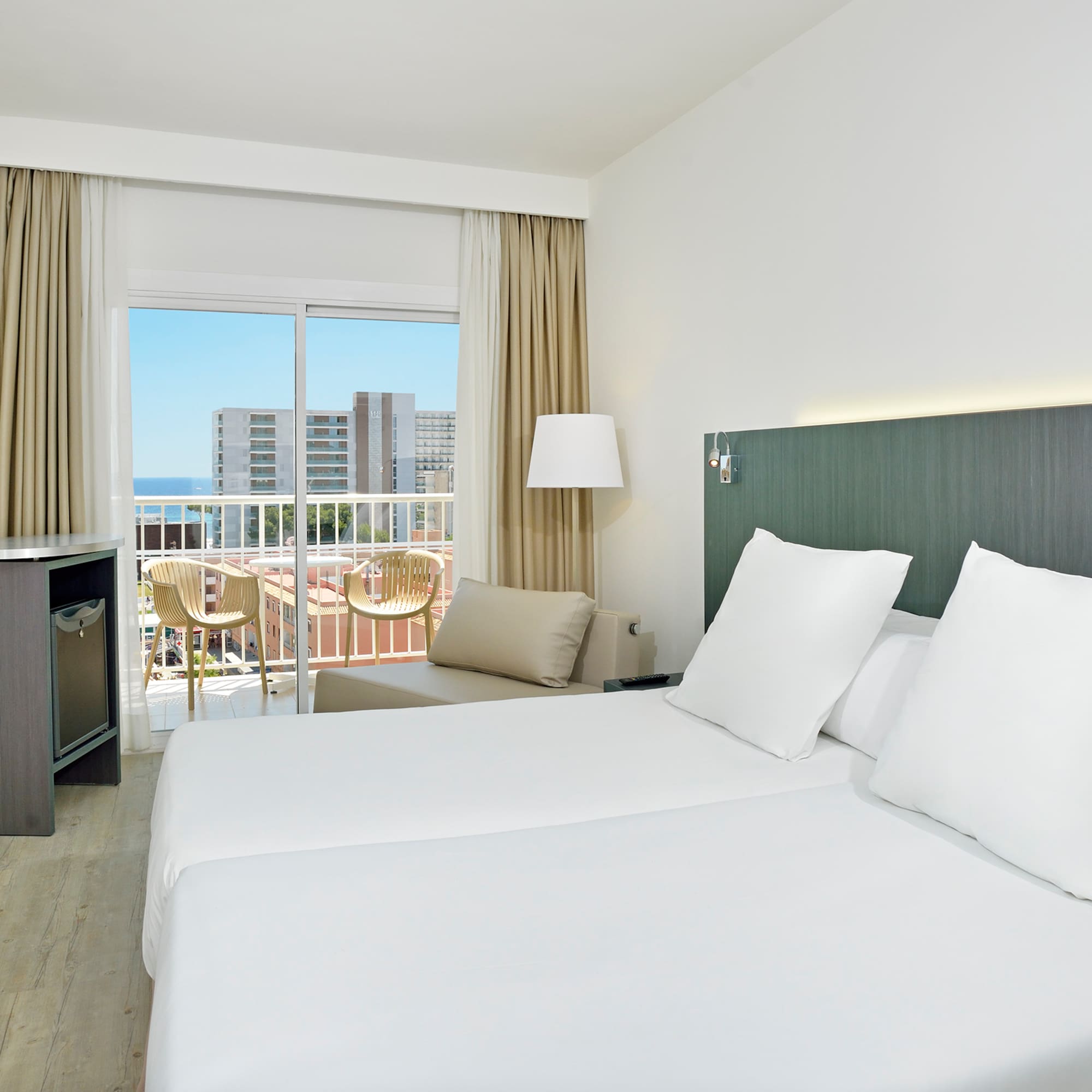 a hotel room with white bedding and a balcony