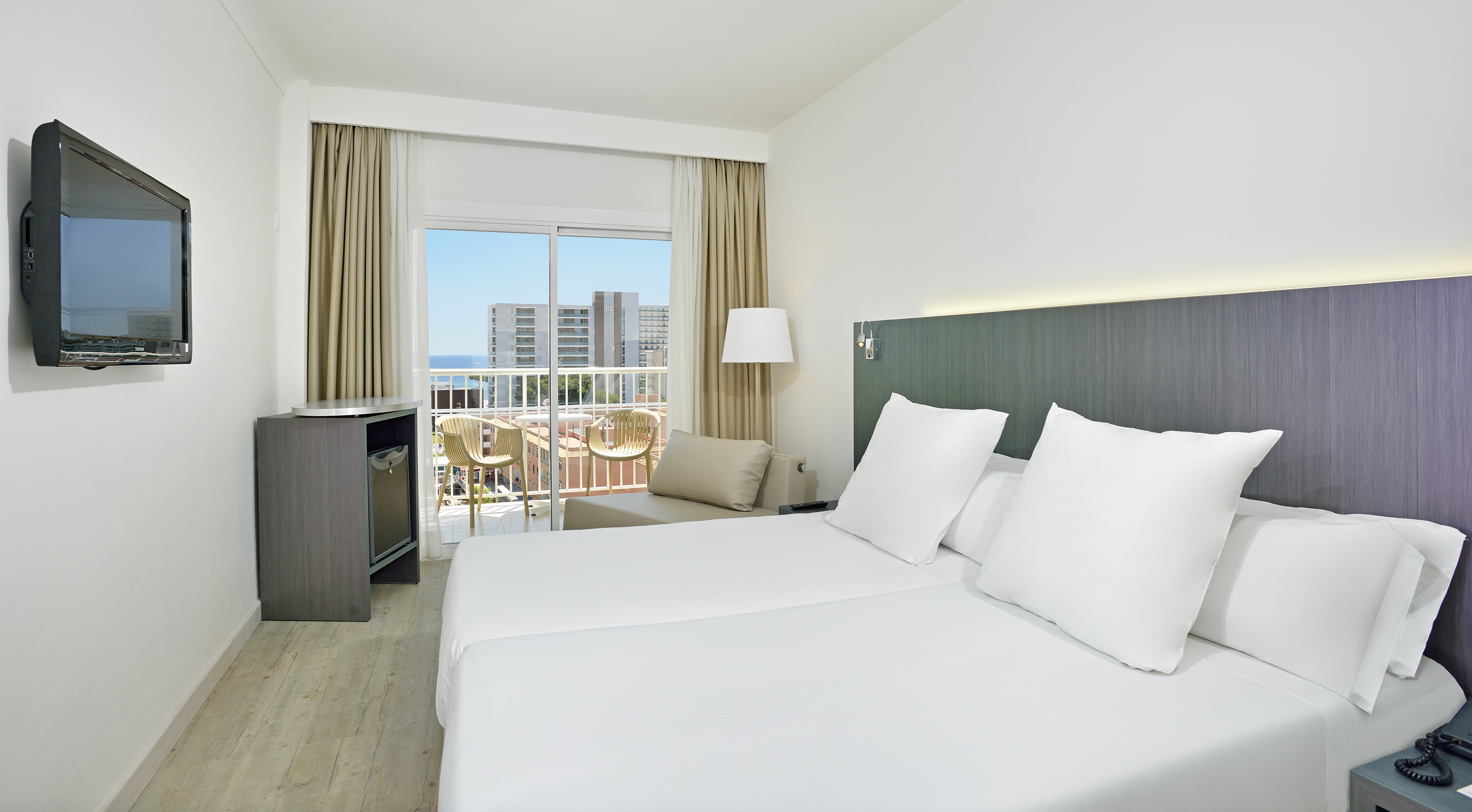 a hotel room with white bedding and a balcony