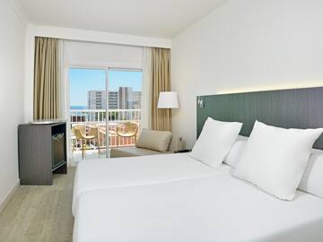 a hotel room with white bedding and a balcony