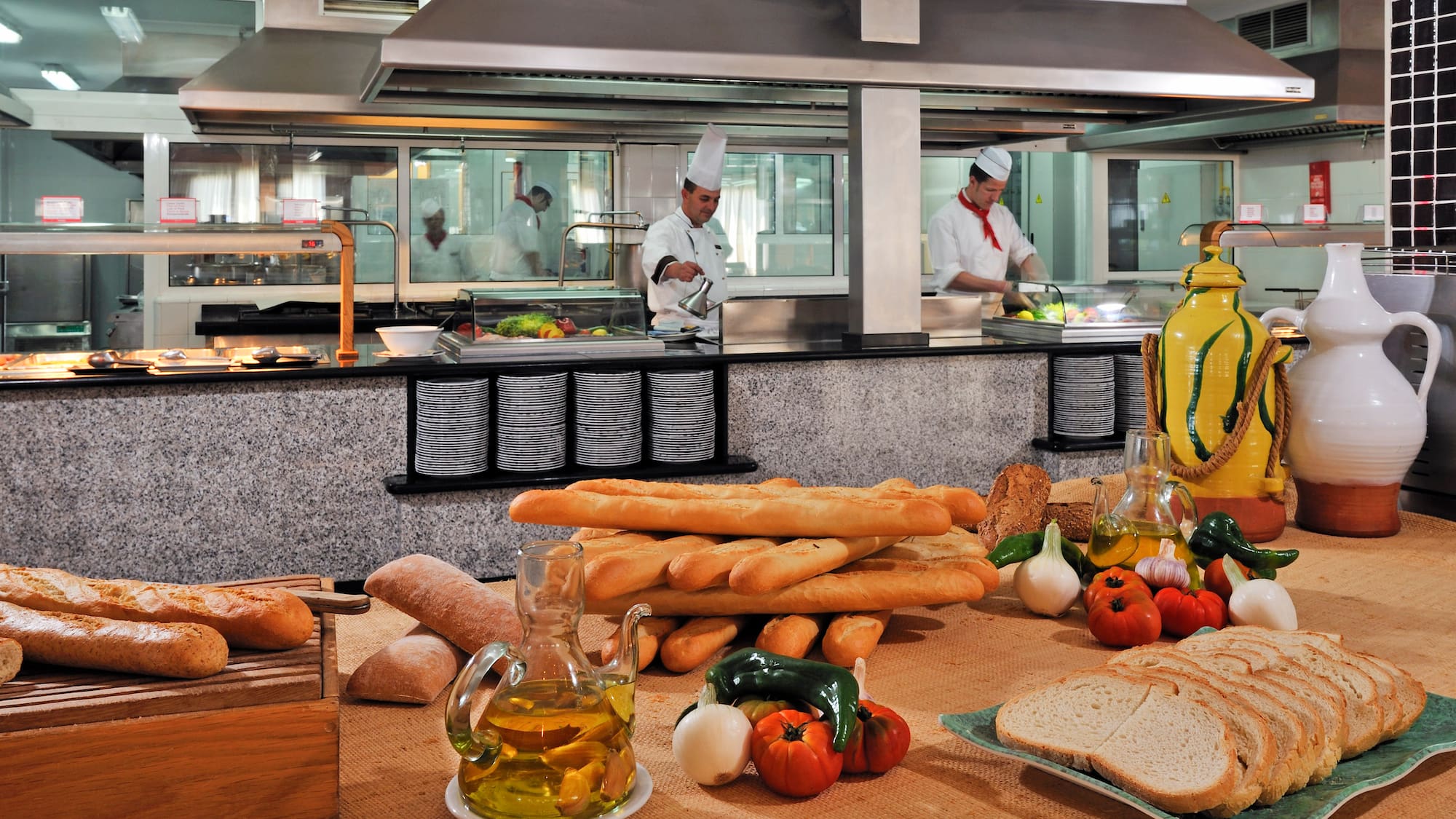 a kitchen with chef cooking in the background