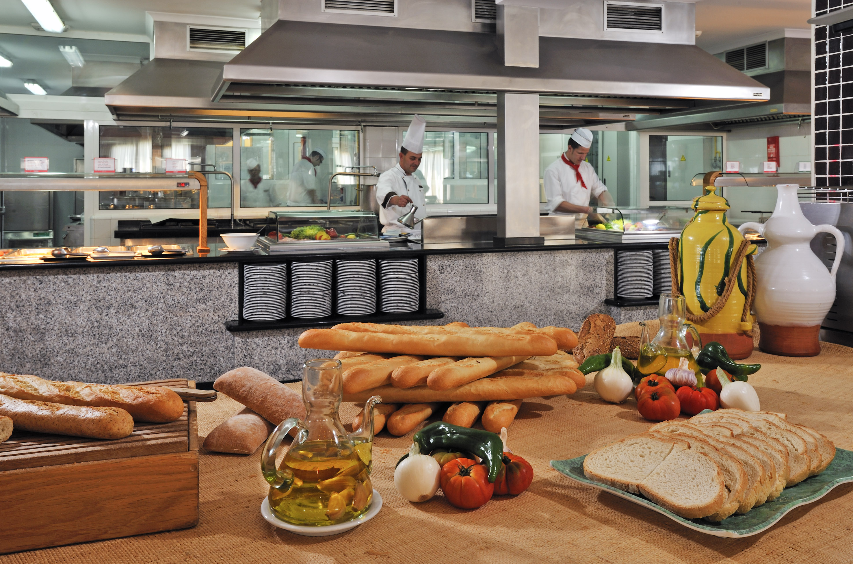 a kitchen with chef cooking in the background