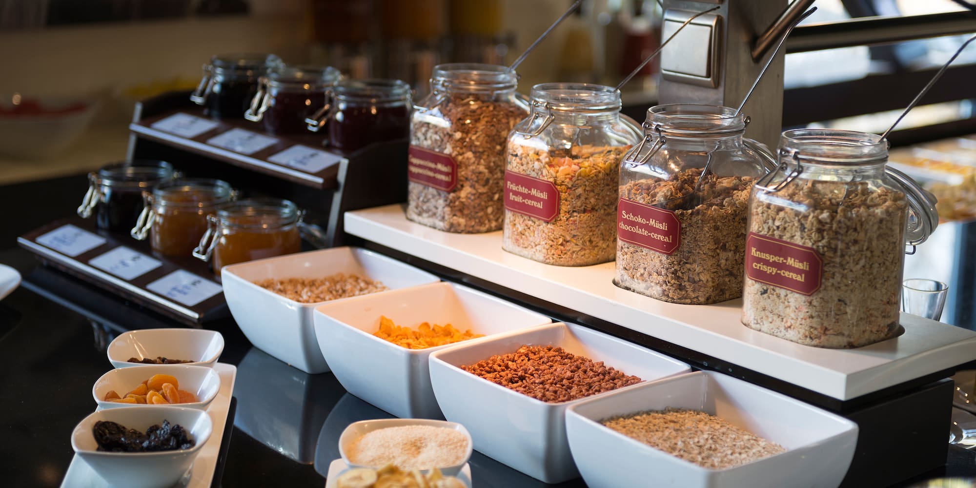 a variety of cereals in containers on a counter