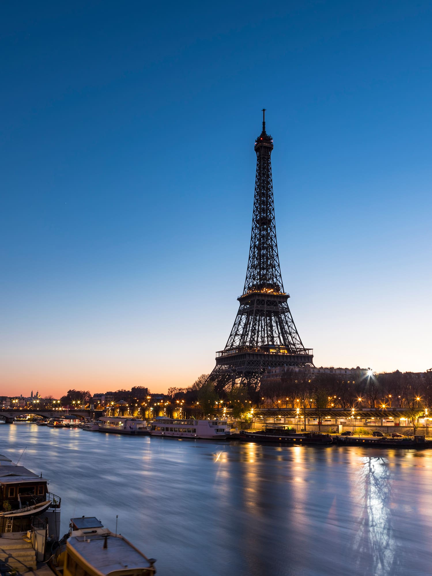 a eiffel tower and a river at night