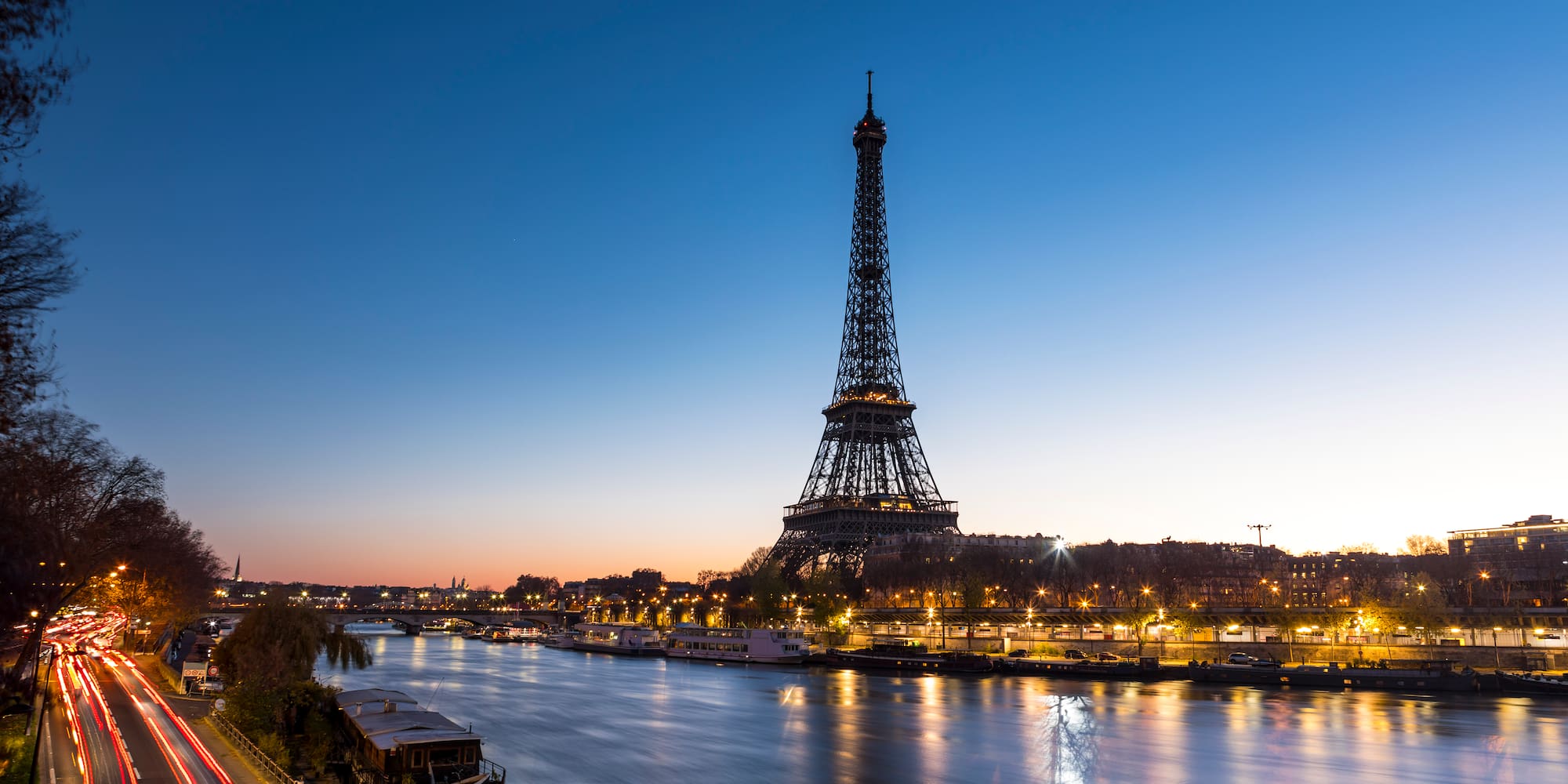 a eiffel tower and a river at night