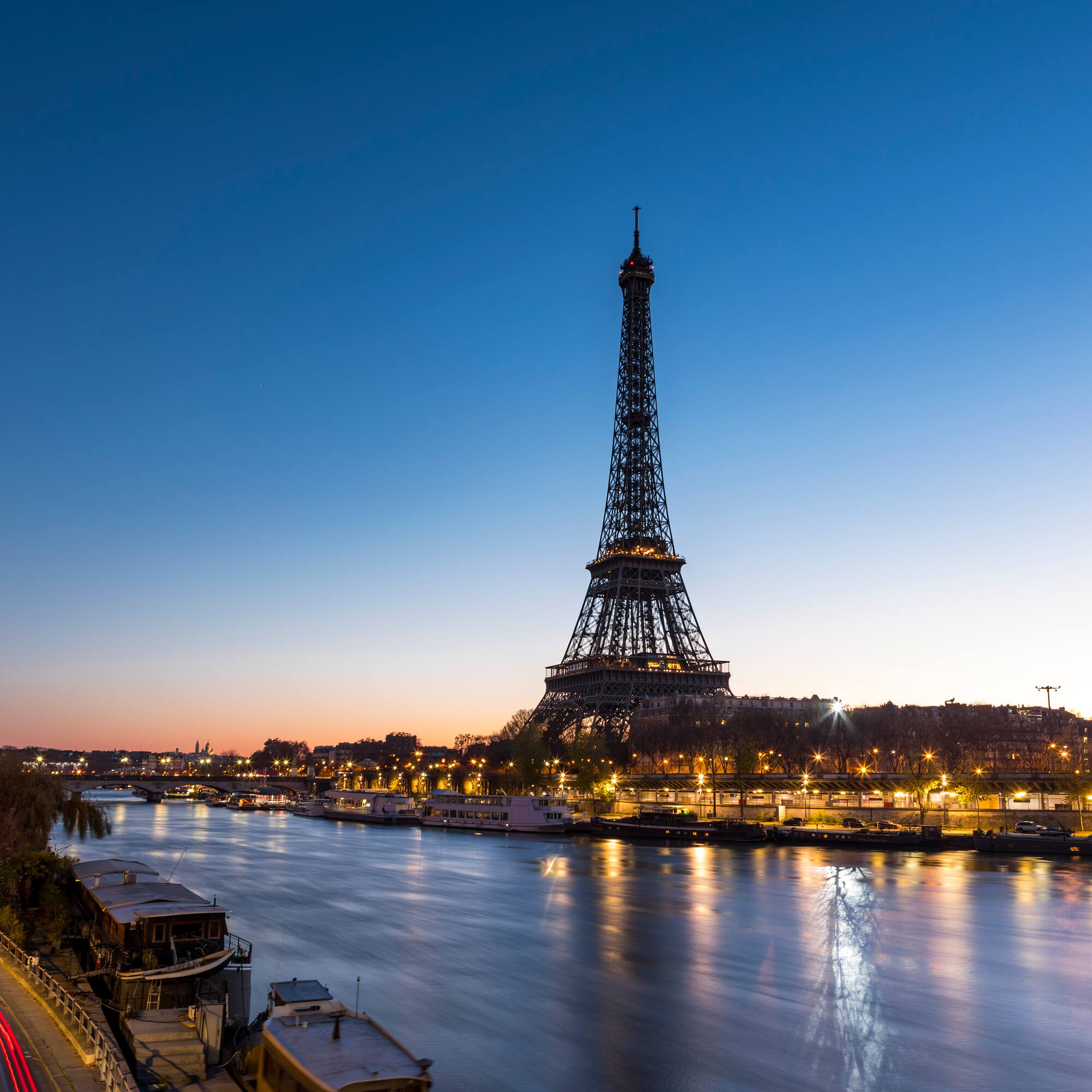 a eiffel tower and a river at night