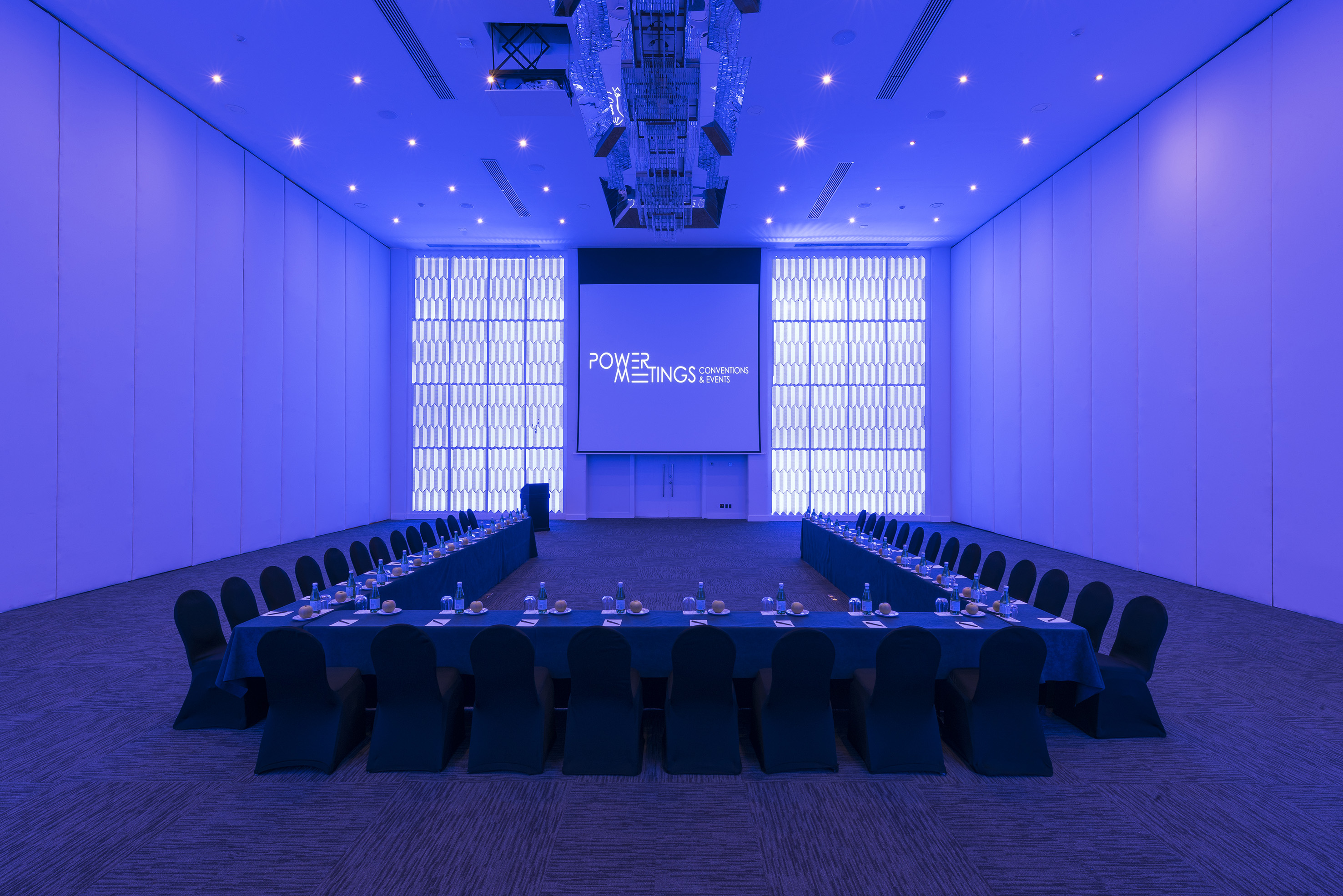 a room with a large screen and a table with chairs