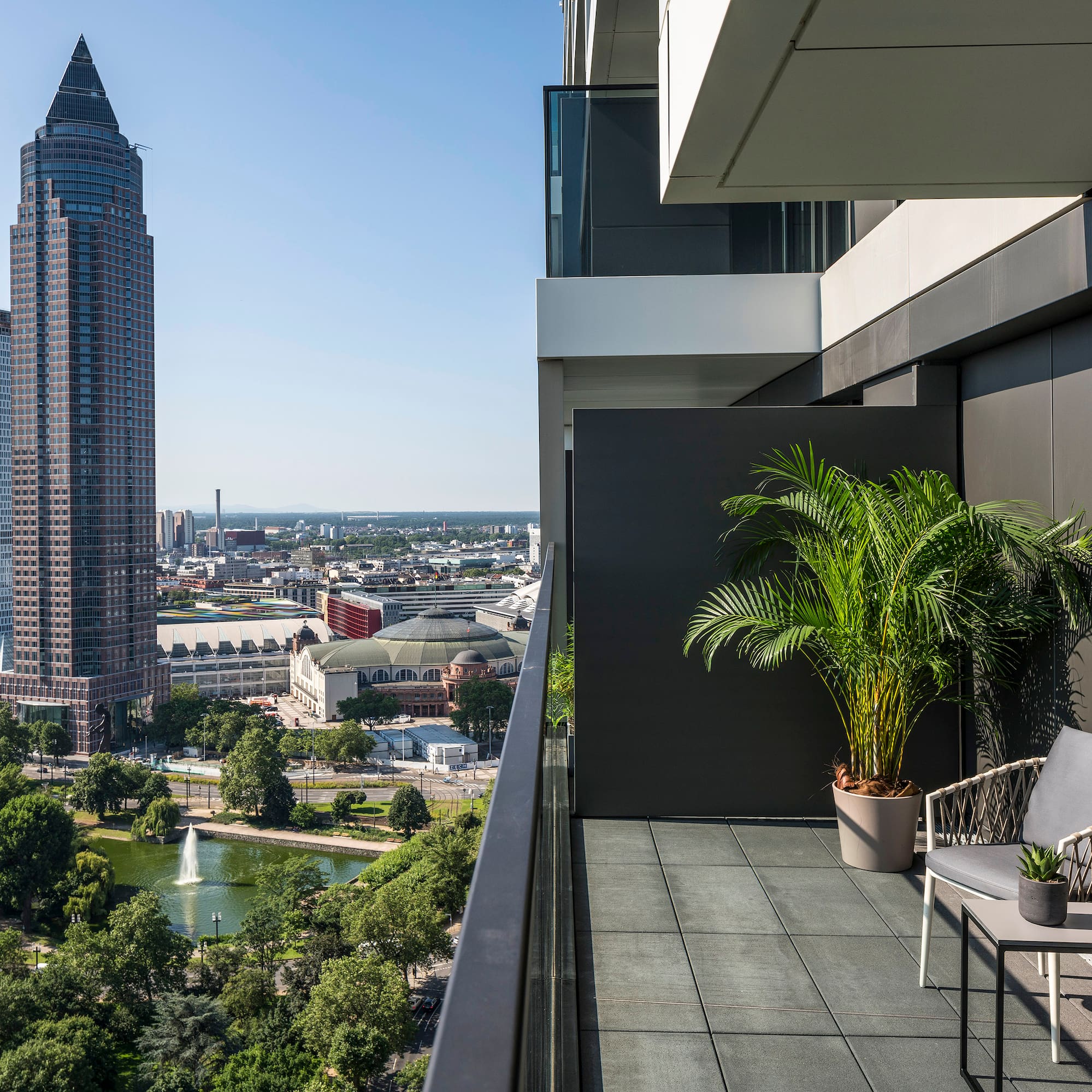 a balcony with a view of a city and a fountain