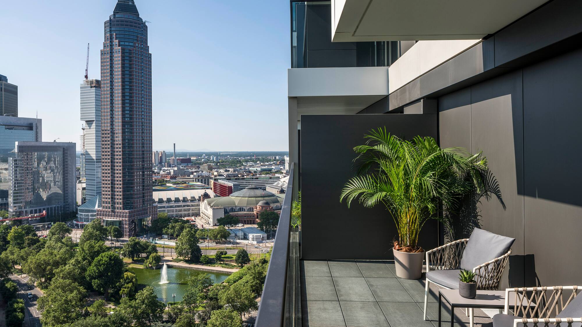 a balcony with a view of a city and a fountain