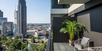 a balcony with a view of a city and a fountain