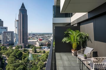 a balcony with a view of a city and a fountain