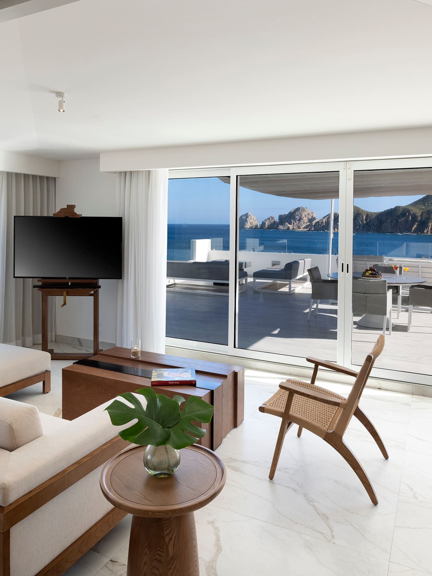 a living room with a television and a view of the ocean