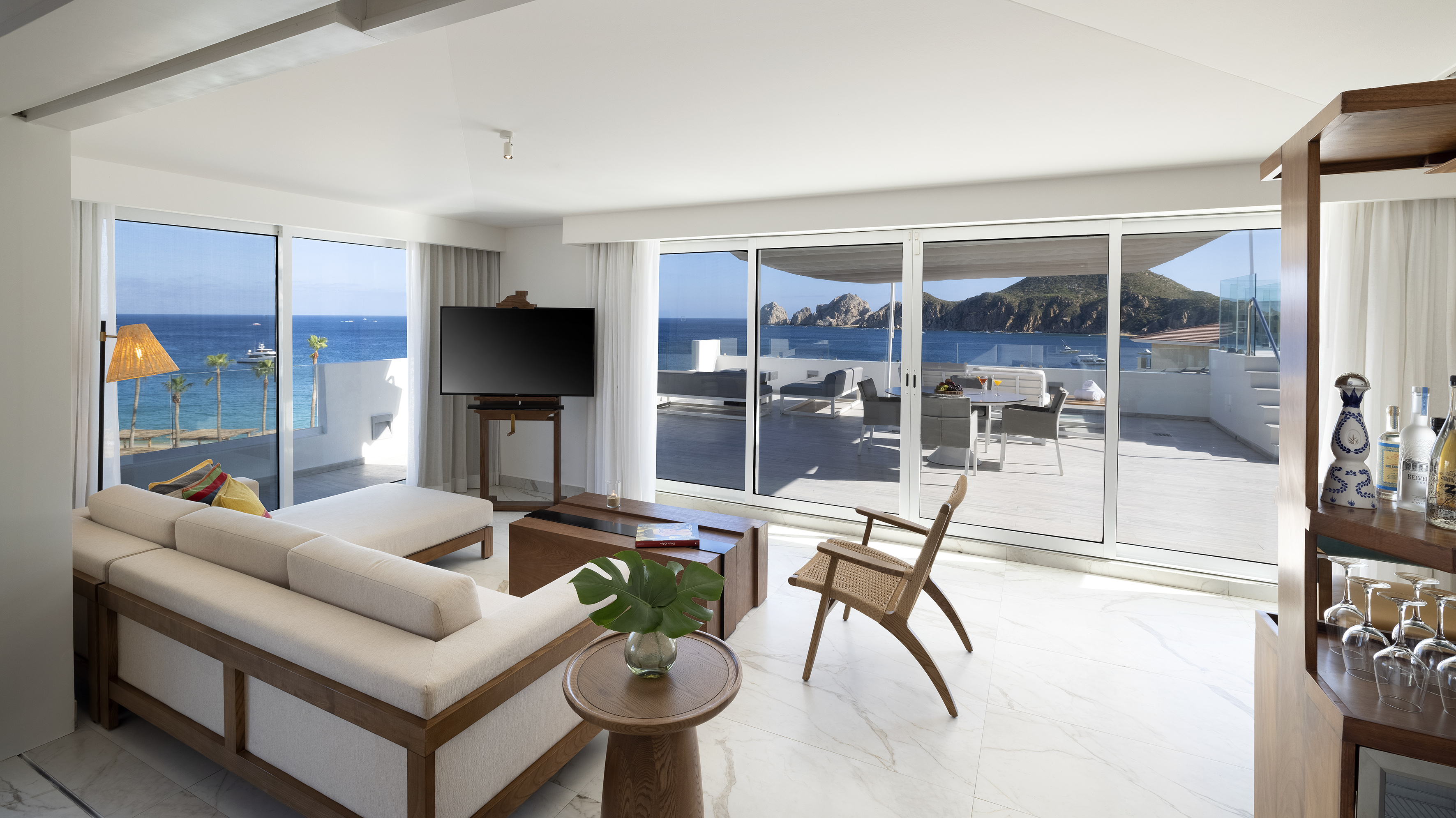 a living room with a television and a view of the ocean