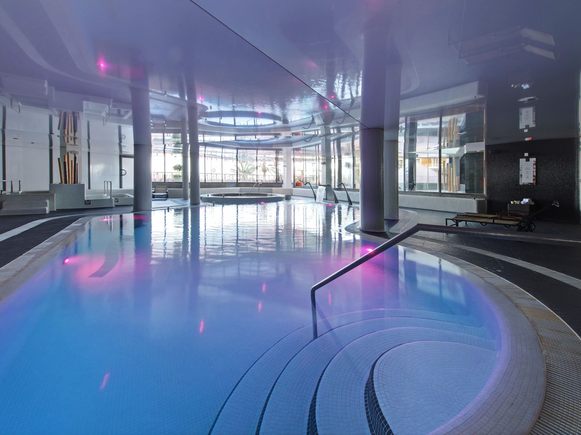 a pool with chairs and a red object in it