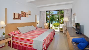 a room with a bed and chairs and a table