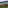 Tuscan hilltop village with terracotta roofs amidst olive groves and rolling hills.