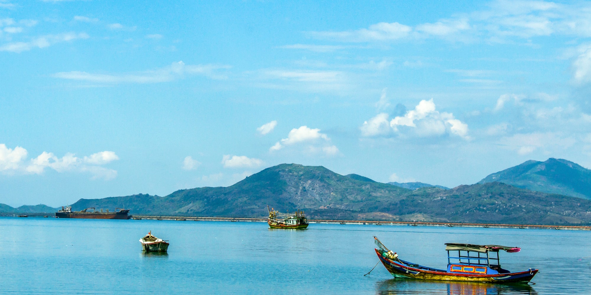 boats in the water with mountains in the background