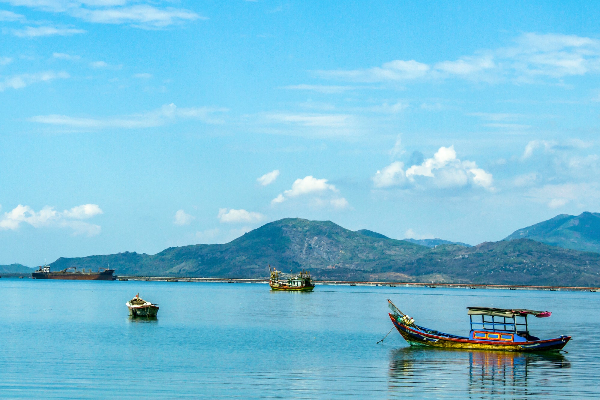boats in the water with mountains in the background