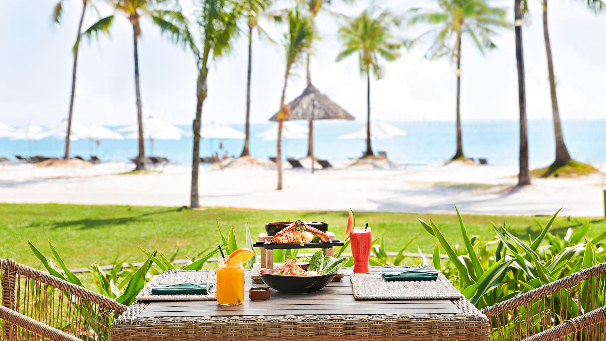 a table with food on it and drinks on the beach