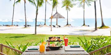 a table with food on it and drinks on the beach