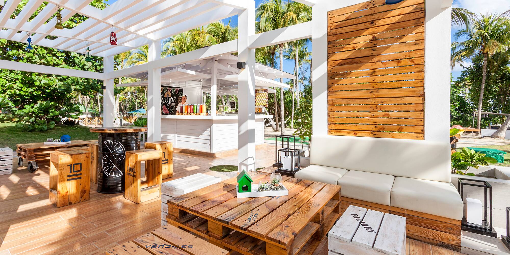 a white patio with wooden tables and chairs