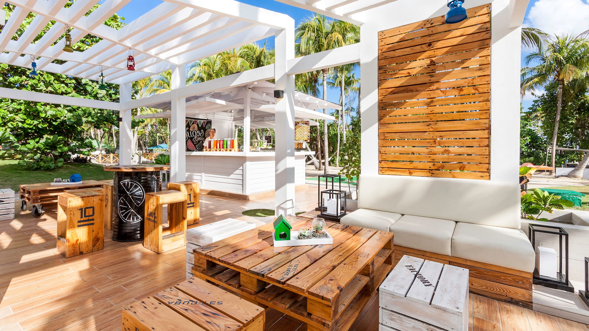 a white patio with wooden tables and chairs