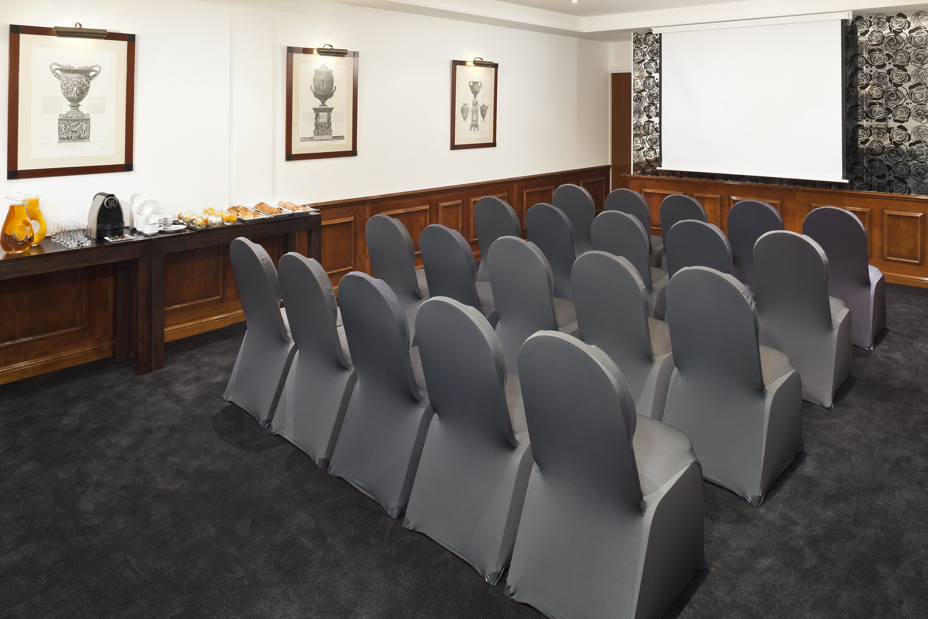 Professional conference room with projector screen, seating, and catering.