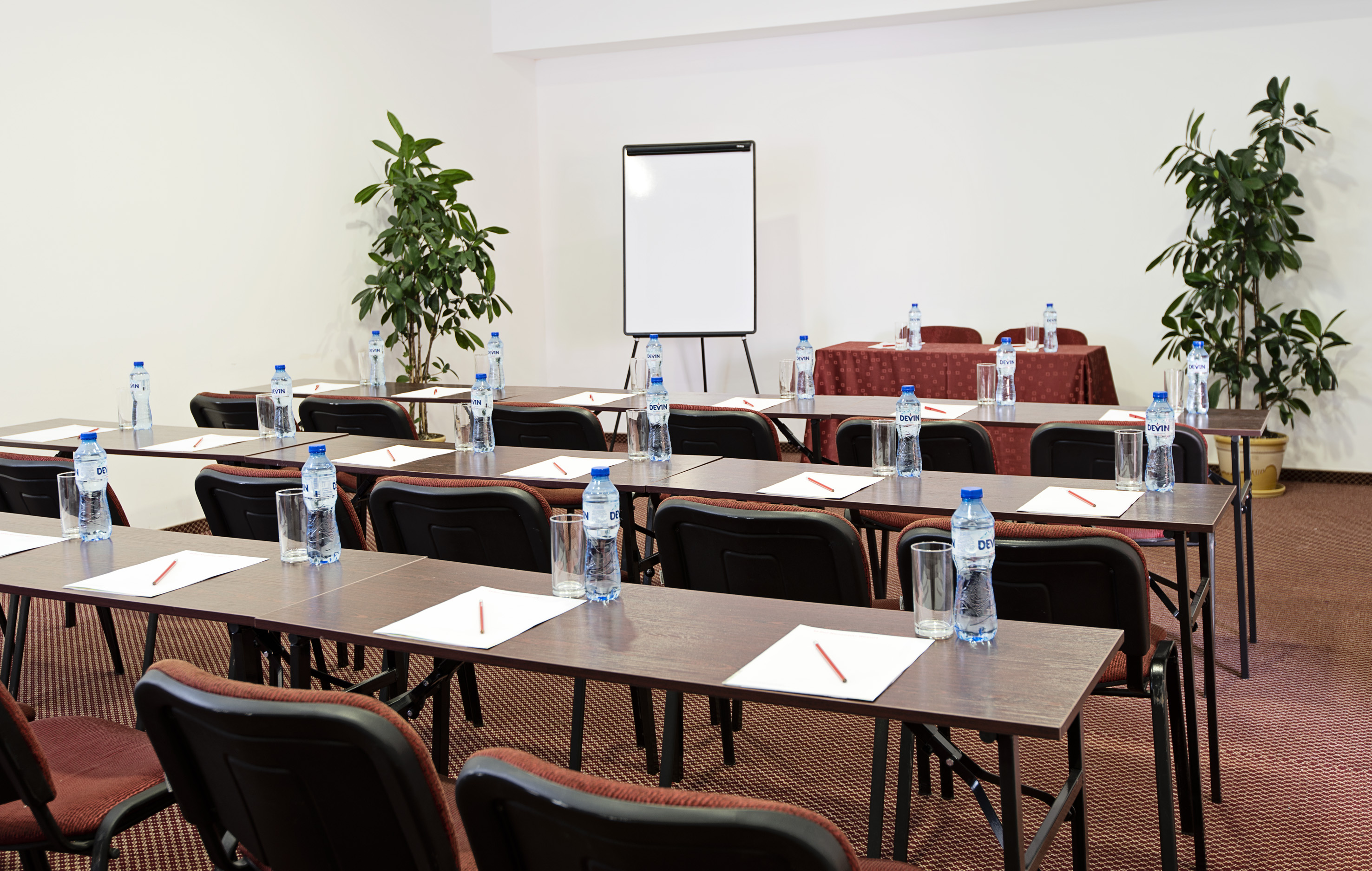 a room with tables and chairs and a white board