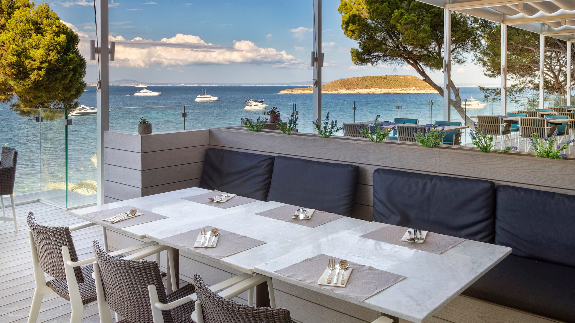a table with chairs and a view of the ocean