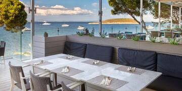 a table with chairs and a view of the ocean