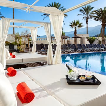 a pool with a white canopy and a tray of food on it