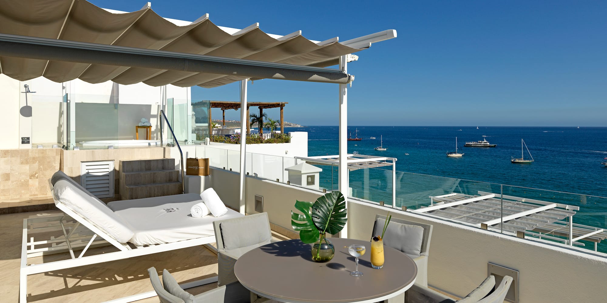 a patio with a table and chairs overlooking the water