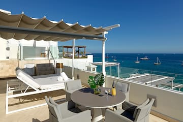 a patio with a table and chairs overlooking the water