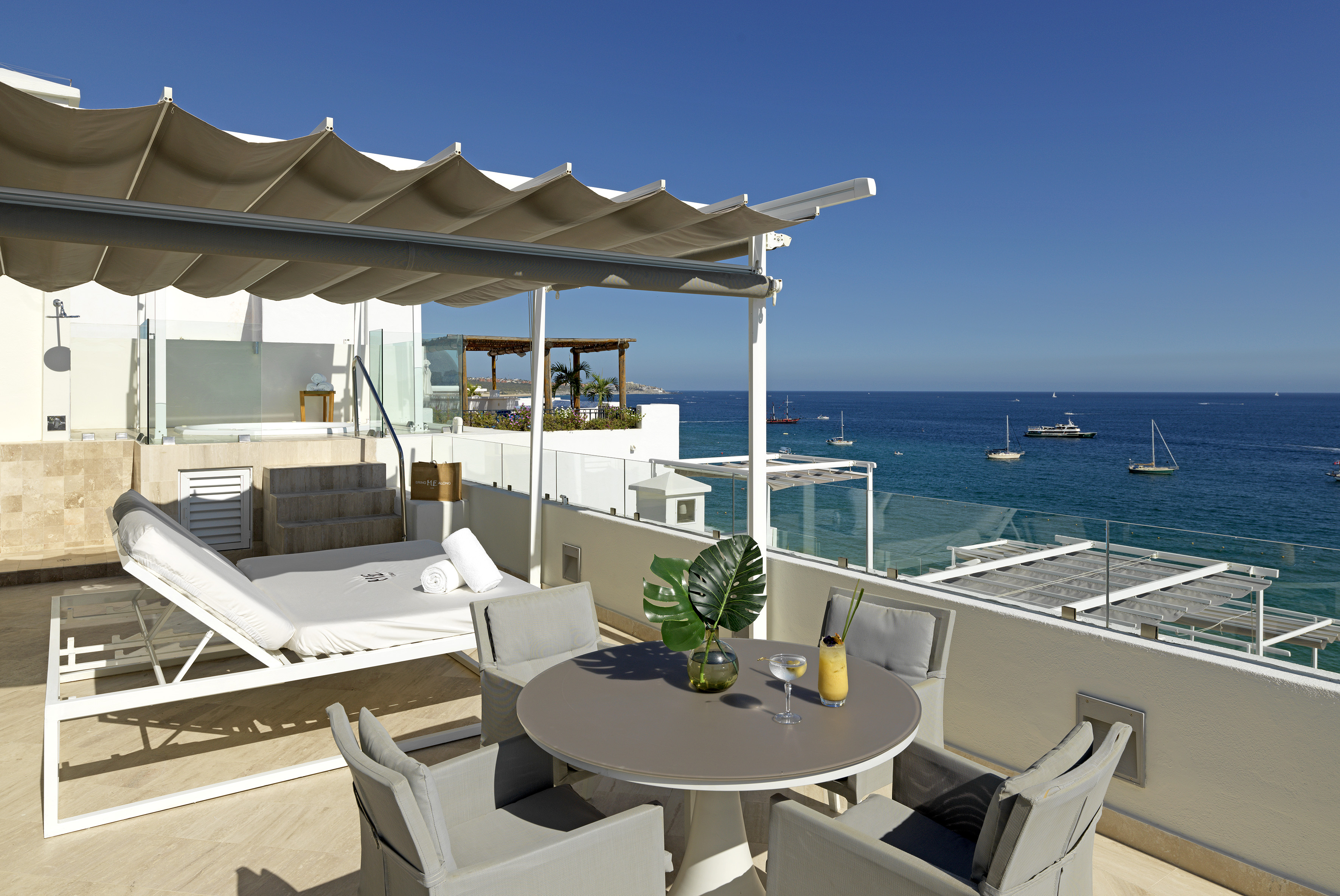 a patio with a table and chairs overlooking the water