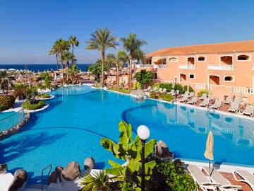 a swimming pool with palm trees and a building