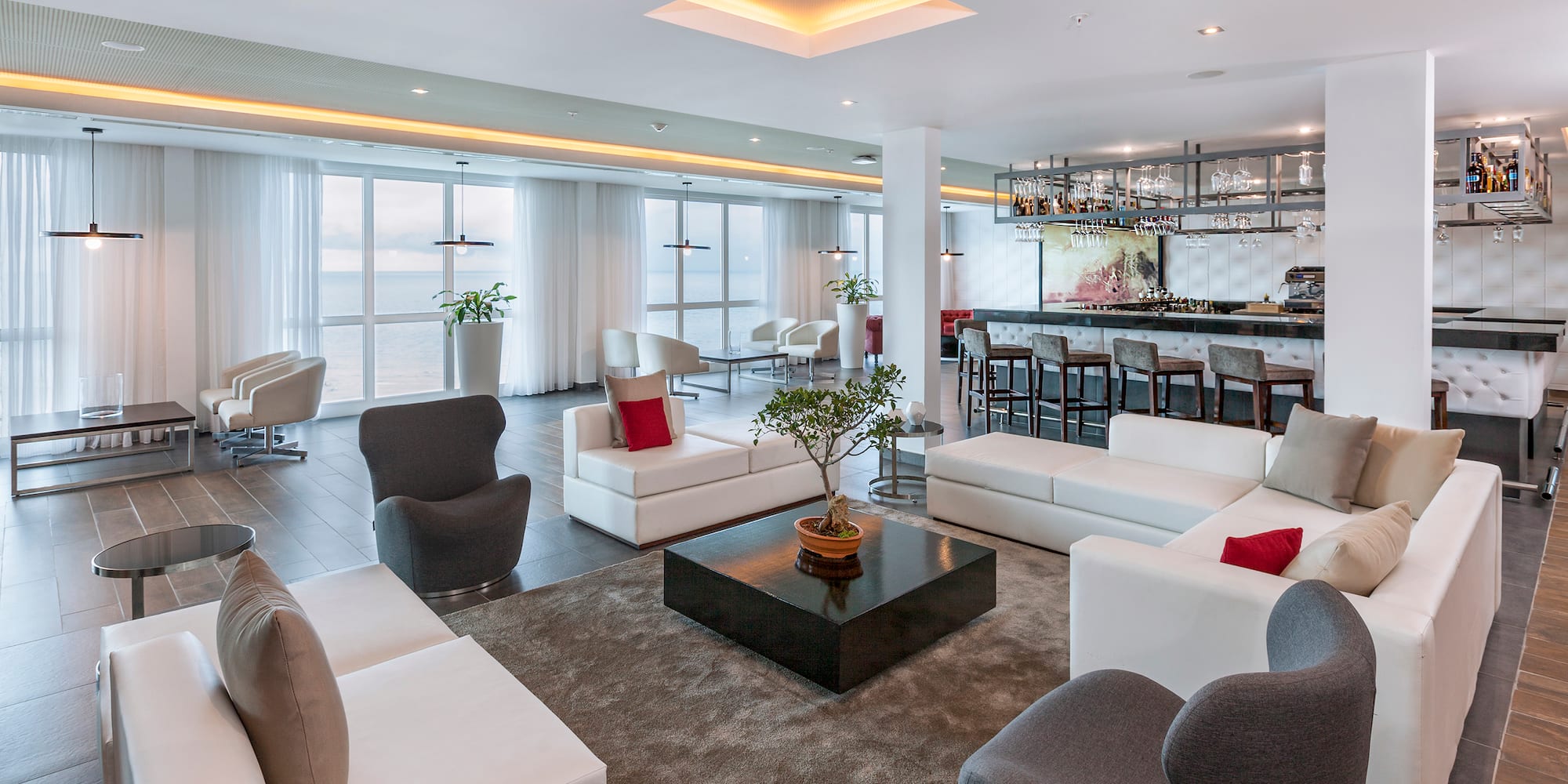 a room with white furniture and a bar