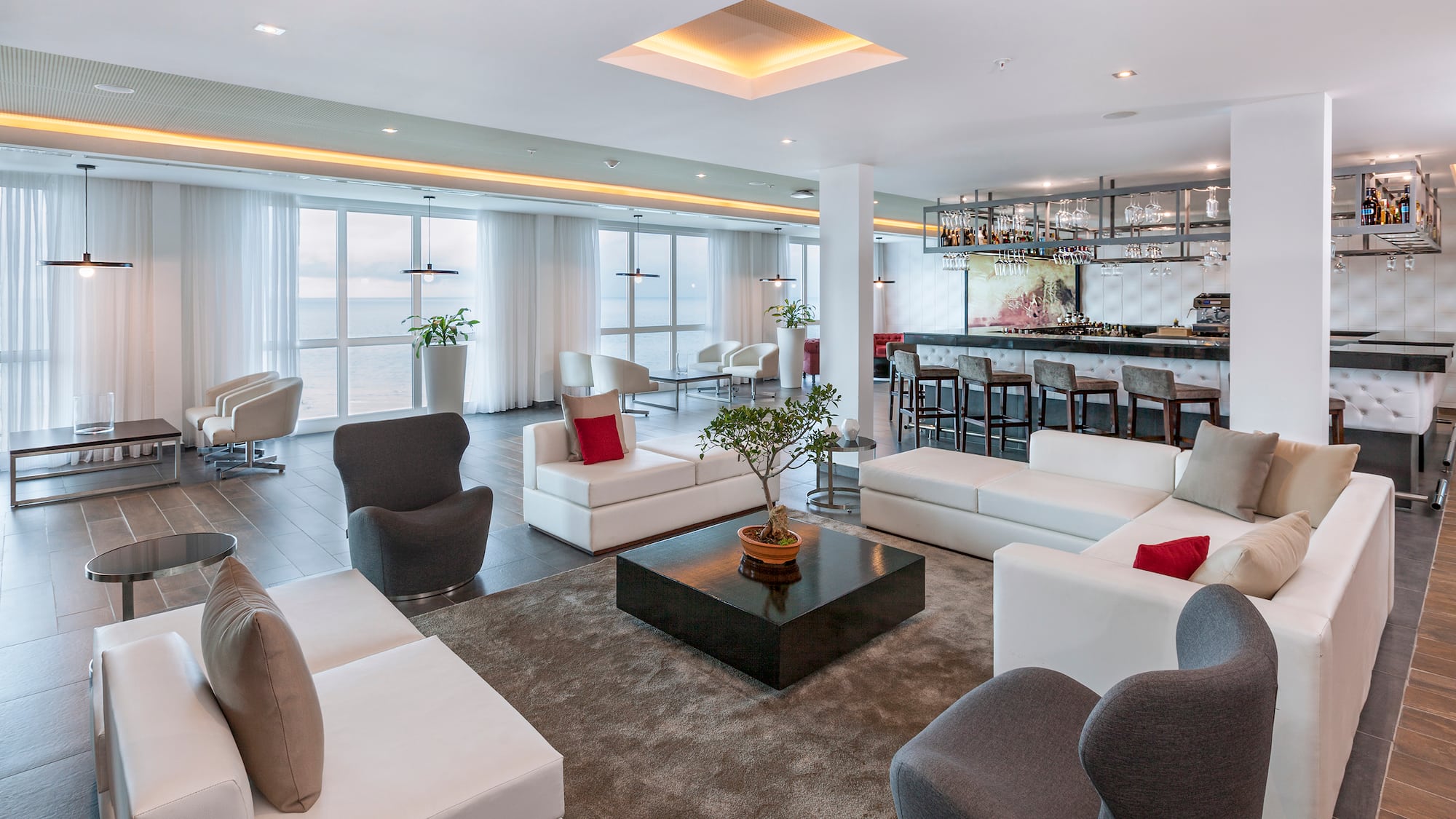 a room with white furniture and a bar