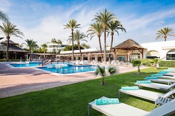 a pool with lounge chairs and palm trees