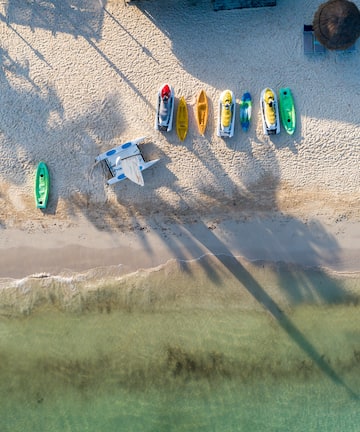a beach with boats and a plane