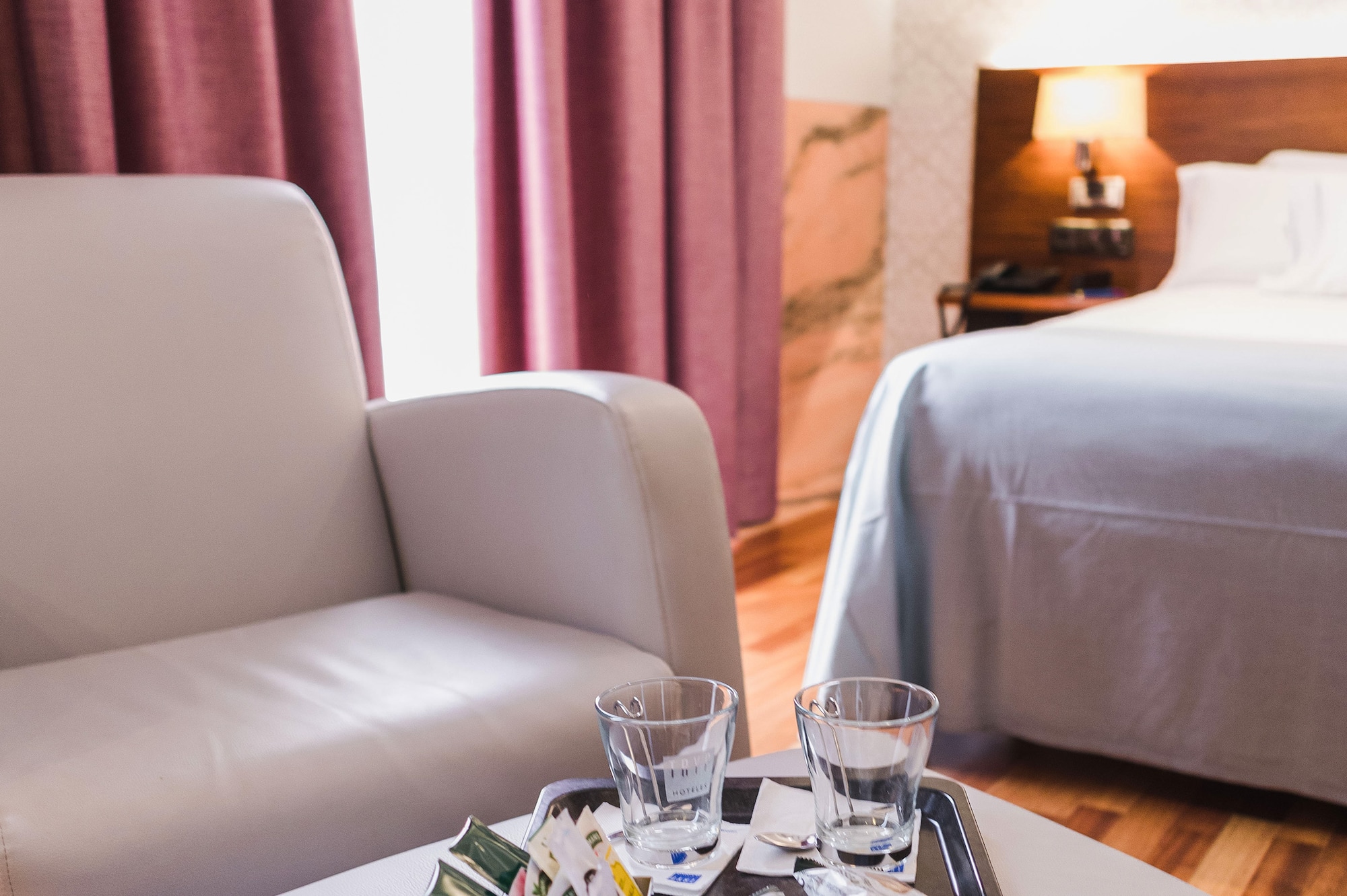 a tray with drinks and glasses on it in a hotel room